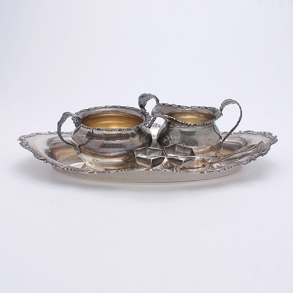 Group of Shreve & Co. Sterling Table Articles:: Group of Shreve & Co. Sterling Table Articles: Comprising a creamer and sugar; a monogrammed bread tray {length 11 1/2 inches}; and two hexagonal salts with spoons; together with a pair of sterling su