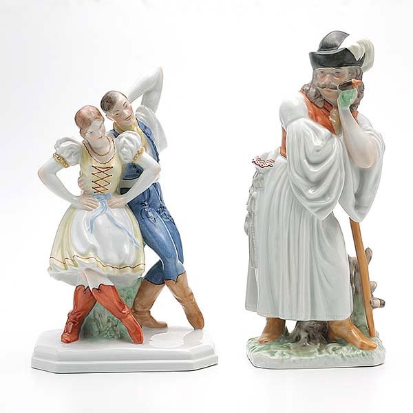 Two Herend Earthenware Figures:: Two Herend Earthenware Figures: Comprising an ethnic male figure with pipe in a traditional costume and a group of male and female dancer {height of tallest 11 1/2 inches}