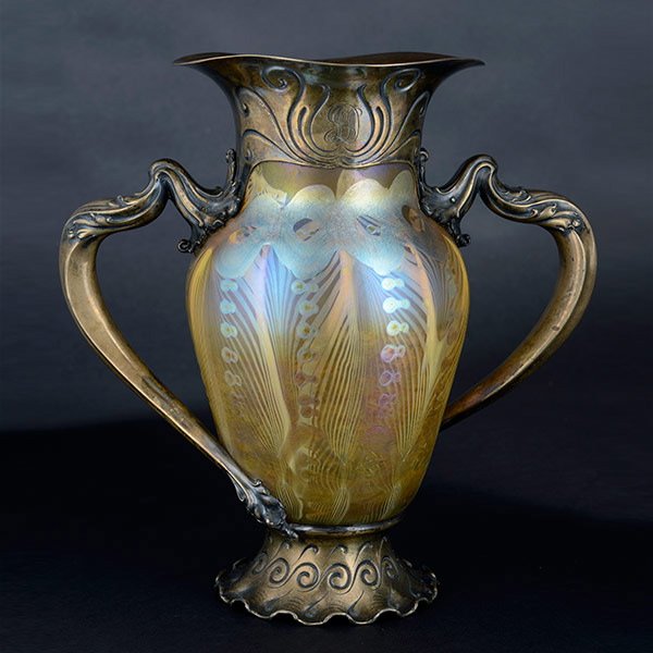Tiffany Studios Silver Mounted Decorated Vase.: Silver Mounted Decorated Vase by the Tiffany Studios. The chased wave and whiplash motifs on the mount are rendered in a vigorous Art Nouveau style uncharacteristic of Tiffany. 'Many of the vases, bow