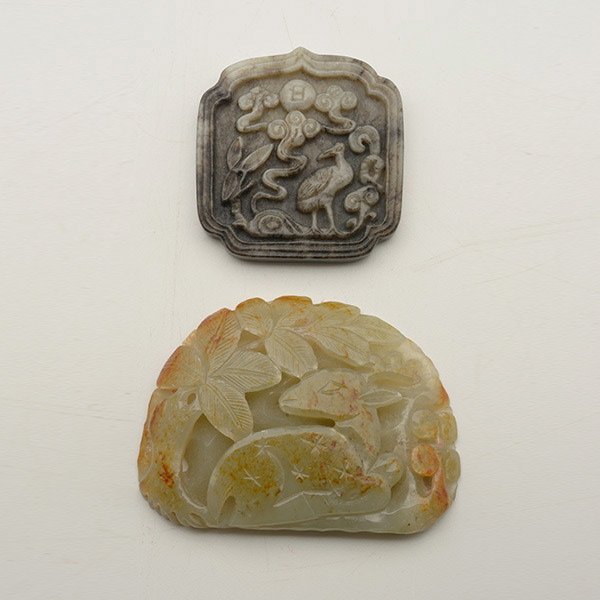 Two Jade Pendants: Two Jade Pendants, The first carved with a deer under a tree, with russet inclusions; the second of ruyi form carved with a crane amongst swirling clouds, with black inclusions. Longest: 3 1/4 inches 