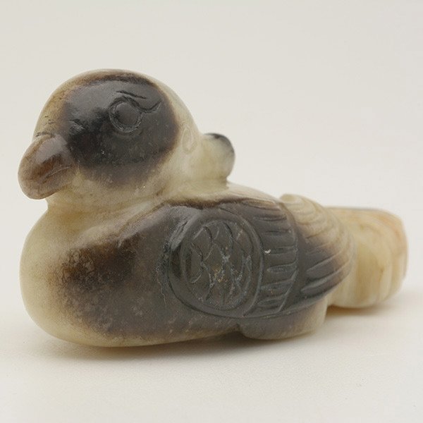 A Jade Model of a Mandarin Duck: A Jade Model of a Mandarin Duck, Carved in the Han dynasty style, the pale celadon stone with black inclusions. Length: 2 5/8 inches (6.7 cm)