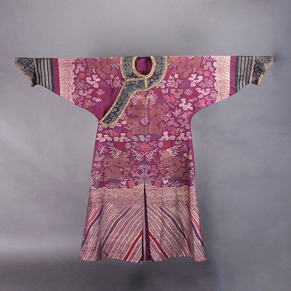 A Brocade Purple-Ground 'Dragon' Robe, Late Qing: A Brocade Purple-Ground 'Dragon' Robe, Displaying nine five-clawed golden dragons in pursuit of flaming pearls amidst colorful swirling clouds, featuring Buddhist and Daoist emblems throughout, all ab