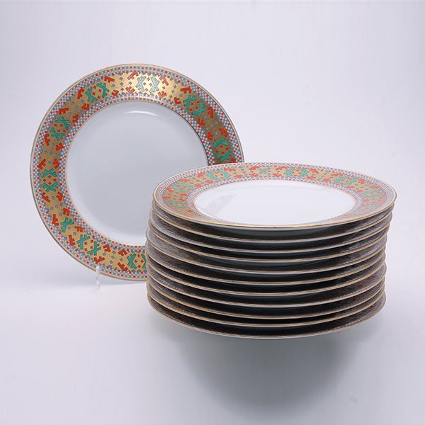 Suite of Twelve Kornilov Painted Plates: Set of Twelve Kornilov Hand Painted Plates. Each ivory ground plate enclosed by gold borders with scattered red, green and blue cross devices, enclosed by checkerboard guards in conforming colors. Dia