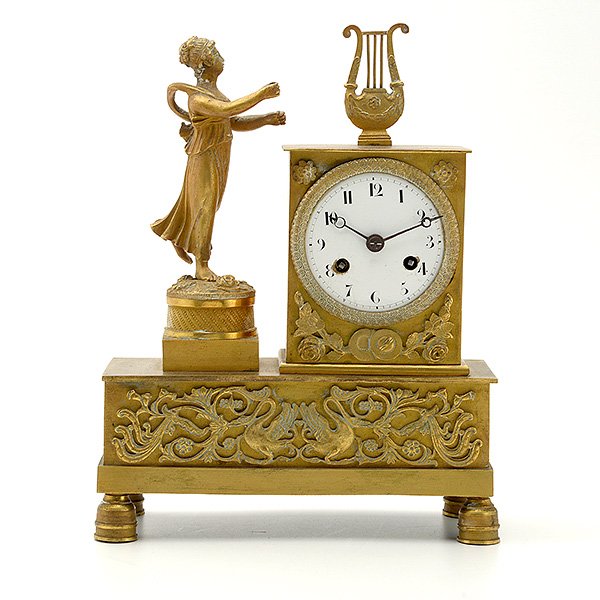 Restauration Gilt Bronze Figural Clock: Restauration Gilt Bronze Figural Clock. The eight day strike movement housed in a table form case adorned by a classical Athenian and a classical draped maiden with lyre, the whole on a lozenge shaped