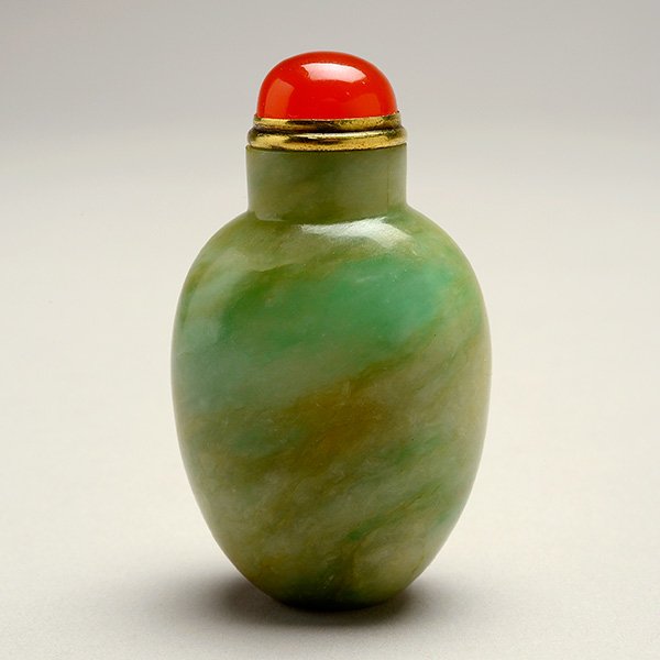 A Jadeite Snuff Bottle, 19th C.: A Jadeite Snuff Bottle Of compressed ovoid form, with a flat lip and a concave oval foot, the interior of the bottle well-hollowed, the stone of green and russet coloration, with a carnelian stopper. 
