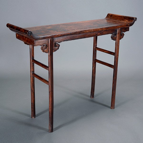 A Huanghuali Altar Table: A Huanghuali Altar Table The floating top panel fitted into a mitered, mortise and tenoned frame with everted flanges over a shaped, beaded apron joined to circular legs and joined to paired oval stre