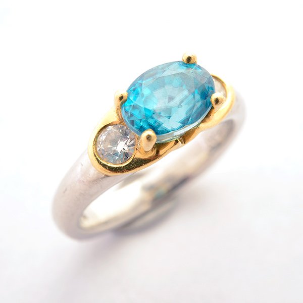 Zircon, Diamond, Platinum, 18k Yellow Gold Ring.: Zircon, Diamond, Platinum, 18k Yellow Gold Ring. Featuring one oval-cut blue zircon weighing approximately 2.80 cts., flanked by two full-cut diamonds weighing a total of approximately 0.25 cttw., set