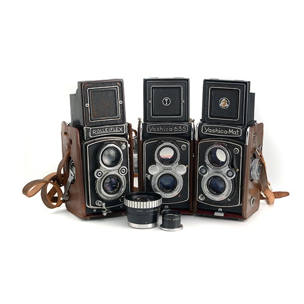 Three Vintage Twin Lens Reflex Cameras: Three Vintage Twin Lens Reflex Cameras: Comprising a Yashica 635 and Mat, each with 80mm lens; and a Rolleiflex with 75mm lens and two adapter lens