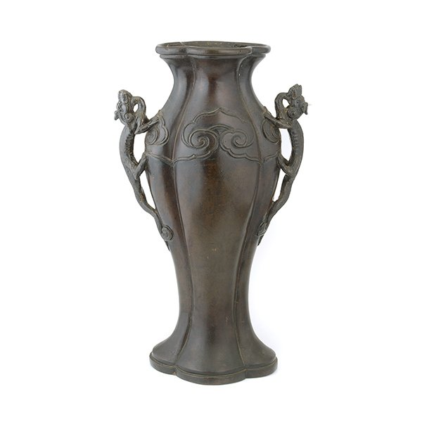 A Bronze Handled Vase: A Bronze Handled Vase Of lobed baluster form, the shoulder encircled by a large ruyi-head border and flanked by a pair of dragon-form handles. {Height: 16 1/2 inches (42 cm)} [Dents, nicks, abrasions,
