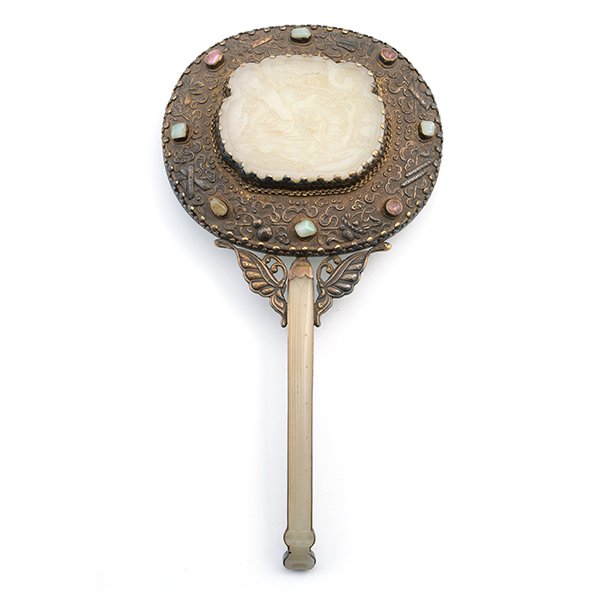 A Jade-Mounted Silver Mirror, Early 20th Century: A Jade-Mounted Silver Mirror The slightly arching jade hairpin forming the slender handle, the ruyi-head jade plaque carved with a figure in a landscape attached to the oval silver mirror back, furthe