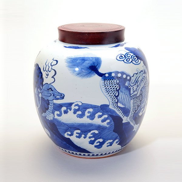An Underglaze Blue Covered Jar, Kangxi Period: An Underglaze Blue Covered Jar Decorated to the exterior with four stylized qilin, each shown perched upon jagged rocks above violently crashing waves, the recessed base with double rings in underglaz