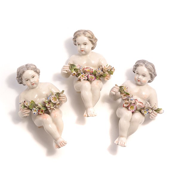 Three Porcelain Cherub Figures Holding Floral Wreaths: Set of Three Seated Porcelain Cherub Figures Holding Floral Wreaths {Height 5 1/2 inches} [small losses]