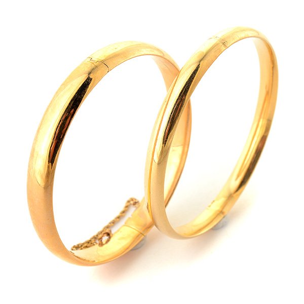 Collection of Two 14k Yellow Gold Bracelets.: Collection of Two 14k Yellow Gold Bracelets. Including one 6 mm hinged 14k yellow gold bangle bracelet together with one 8.50 mm 14k yellow gold bangle bracelet with a safety chain. {Gross Weight: 11.