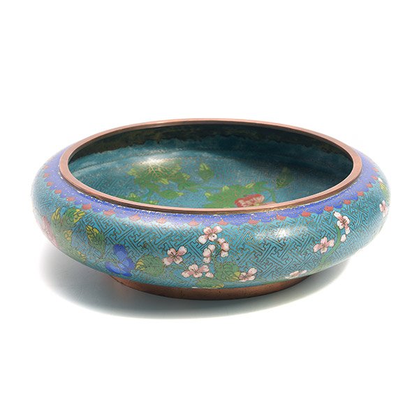 A CloisonnÈ Enamel Low Bowl: A CloisonnÈ Enamel Low Bowl Enameled with various flowers against a turquoise ground of wan frets. {Diameter: 12 inches (30.5 cm) approximately} [Chips, small cracks, soiling, staining]