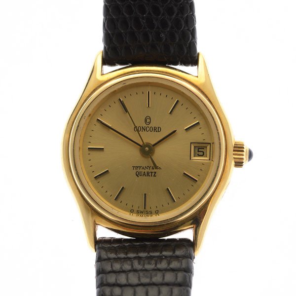 Concord 14k Yellow Gold, Leather, Metal Wristwatch.: Concord 14k Yellow Gold, Leather, Metal Wristwatch. DIAL: Round, gold, black hour markers, black dot outer minutes track, aperture for date at 6 o'clock, black and gold baton hands, Concord, Tiffany &