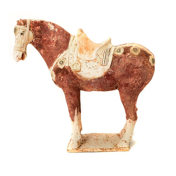 A Tang Style Painted Pottery Horse: A Tang Style Painted Pottery Horse Molded with its head turned to the left, the saddle and saddle blanket picked out in orange and black on a buff colored ground. {Height: 14 3/8 inches (36.5 cm)} [Lo