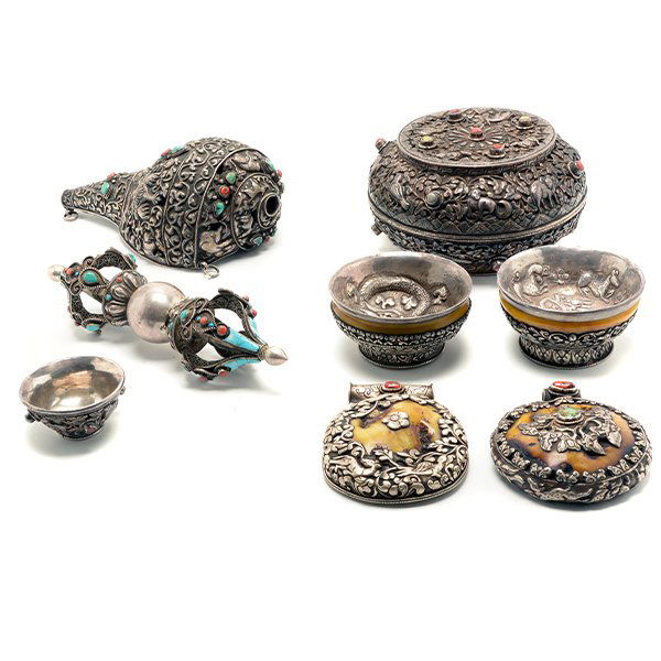 Eight Tibetan Buddhist Ritual and Decorative Objects*: Eight Tibetan Buddhist Ritual and Decorative Objects* Comprising a conch shell, a silver vajra, a circular covered box, two large butterscotch amber pendants, and three tsampa bowls with two made from