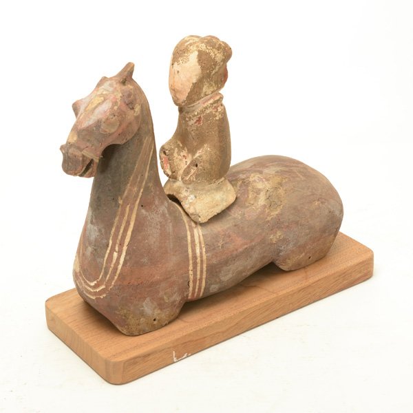 A Pottery Horse and Rider, Han Dynasty: A Pottery Horse and Rider The two-piece model made from unglazed pottery exhibiting traces of pigments throughout, the stylized horse painted with various designs in red, black and white, fitted wood 