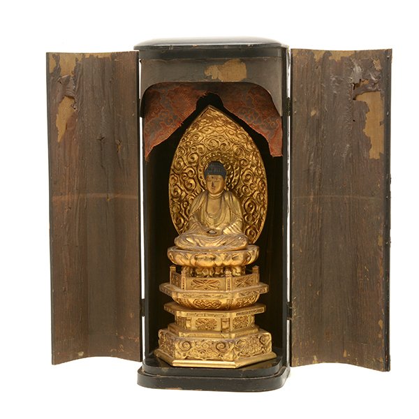A Japanese Gilt-Lacquered Traveling Buddhist Shrine,: A Japanese Gilt-Lacquered Traveling Buddhist Shrine The shrine with hinged double doors opening to reveal a gilt-painted robed figure seated upon a carved tiered stand. Edo Period {Height: 21 1/2 inch
