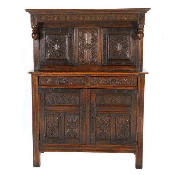 Gothic Revival Oak Court Cupboard: Gothic Revival Oak Court Cupboard. The colonnaded upper section with twin doors, each carved with an entwining vine design, centering an architrave panel, the lower section consisting of twin drawers 