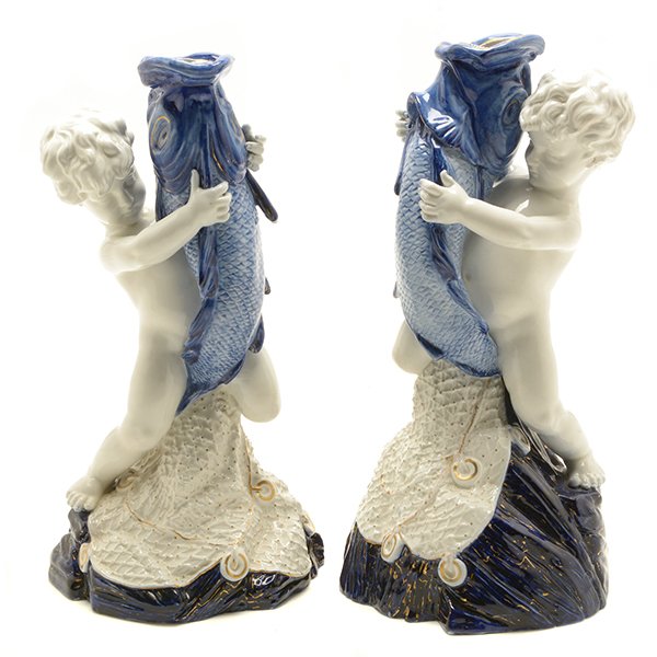 Pair of Royal Worcester Porcelain Figures of Cupid As: Pair of Royal Worcester Porcelain Figures of Cupid As Fisherman. Each pyramidal form modelled as a nude child partially straddling a large fish with his net on a stylized base, marked and impressed wi