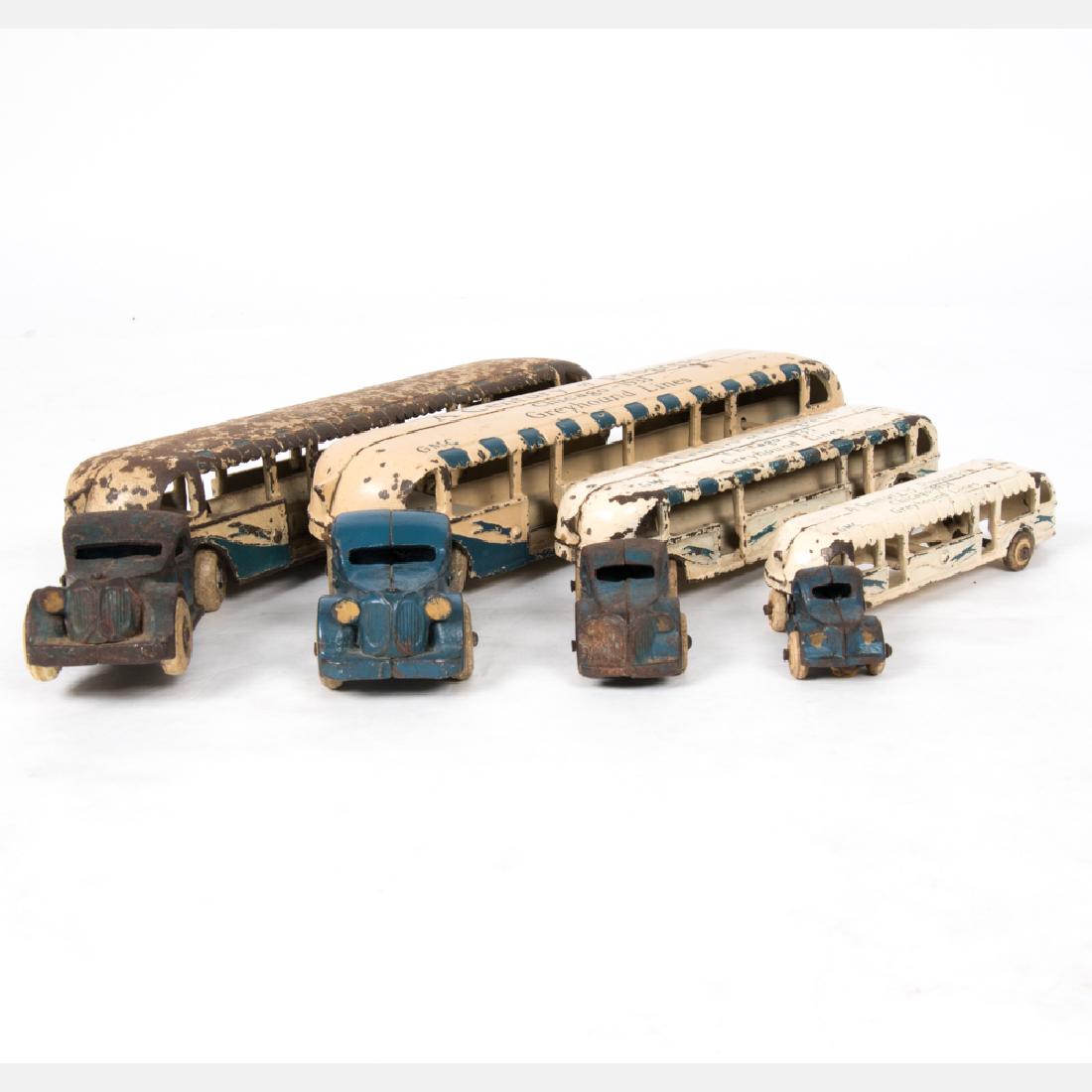 A Group of Four Painted Cast Iron Greyhound Buses by: A Group of Four Painted Cast Iron Greyhound Buses by Arcade Mfg. from the Century of Progress World's Fair, Chicago, 1933, Of varying sizes. Largest dimensions: h: 2 1/2 x w: 14 1/4 x d: 3 1/8 in.