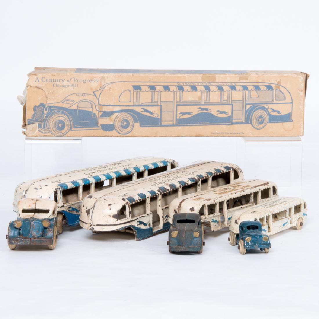 A Group of Four Painted Cast Iron Greyhound Buses by: A Group of Four Painted Cast Iron Greyhound Buses by Arcade Mfg. from the Century of Progress World's Fair, Chicago, 1933, Of varying sizes, one with original box. Box dimensions: h: 3 1/4 x w: 14 1/2