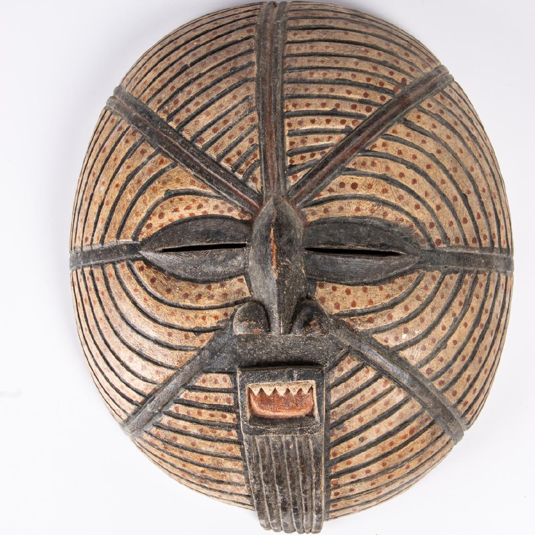 A Luba Tribe Carved and Painted Wood Moon Mask,: A Luba Tribe Carved and Painted Wood Moon Mask, Democratic Republic of Congo, 20th Century, Having almond shaped eyes, a small nose and prominent mouth. H: 17 1/2 W: 14 3/4 D: 5 1/2 in.