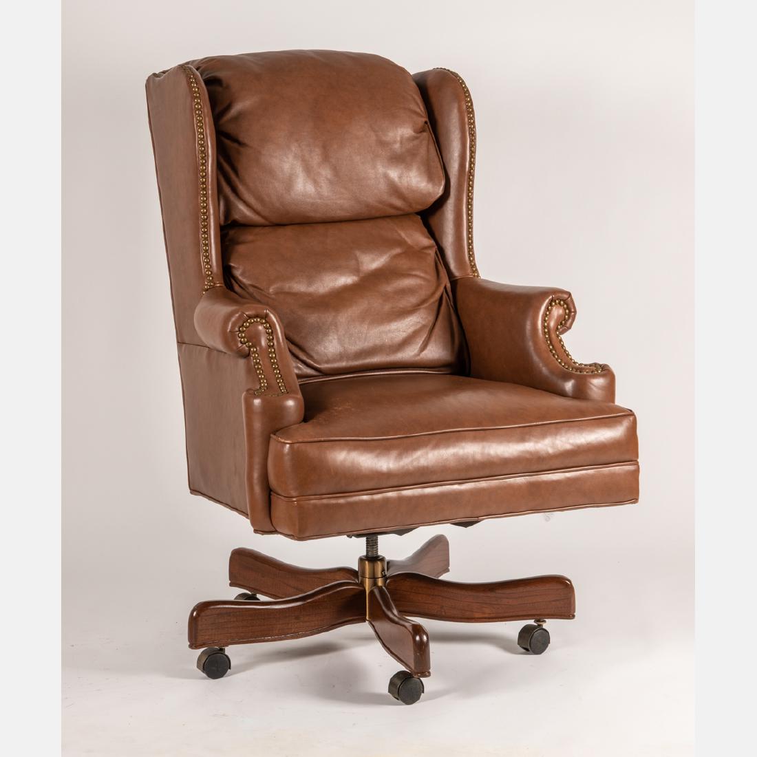 A Leather Upholstered Wingback Swivel Armchair, 20th: A Leather Upholstered Wingback Swivel Armchair, 20th Century. H: 44 W: 31 D: 28 in.