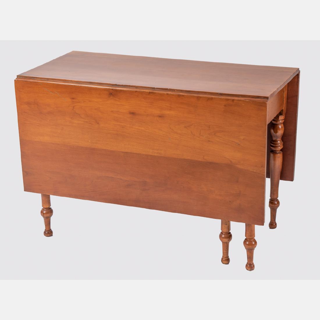 An American Drop Leaf Table, 19th Century,: An American Drop Leaf Table, 19th Century, Having a rectangular top and leaves raised on turned legs. H: 29 W: 43 D: 22 in.