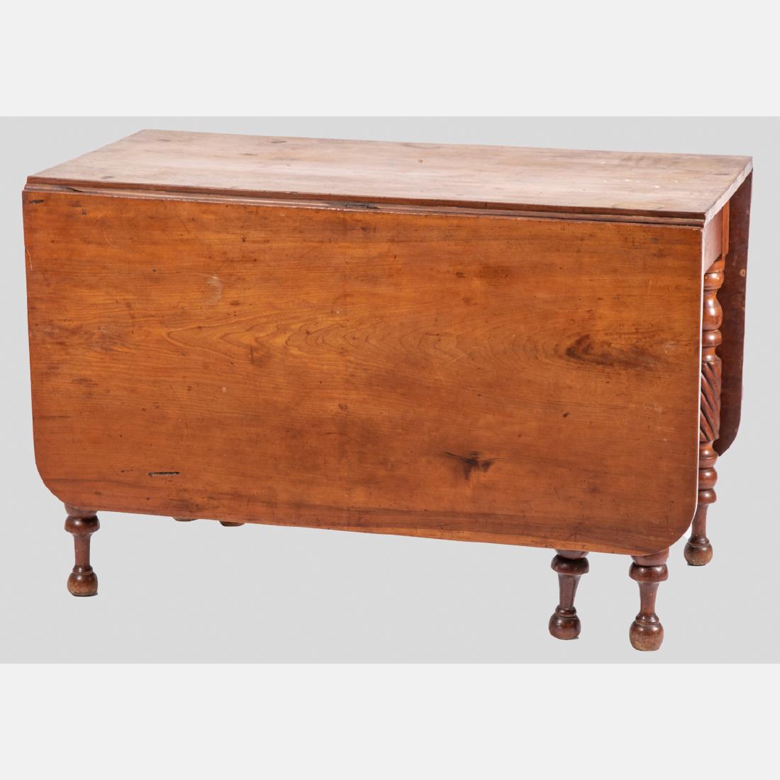 An American Cherry Drop Leaf Table, 19th Century.: An American Cherry Drop Leaf Table, 19th Century. H: 38 3/4 W: 44 3/8 D: 23 in.