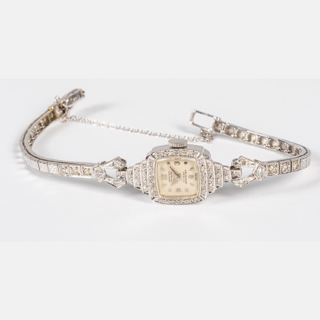 A Ladies 14kt. White Gold and Diamond Wrist Watch by: A Ladies 14kt. White Gold and Diamond Wrist Watch by Croton Incabloc Nivade Grenchen, Swiss, Set with fifty-two round brilliant cut diamond melee, each approx. 0.01-0.03pts. Marked 14k. Total approx. 