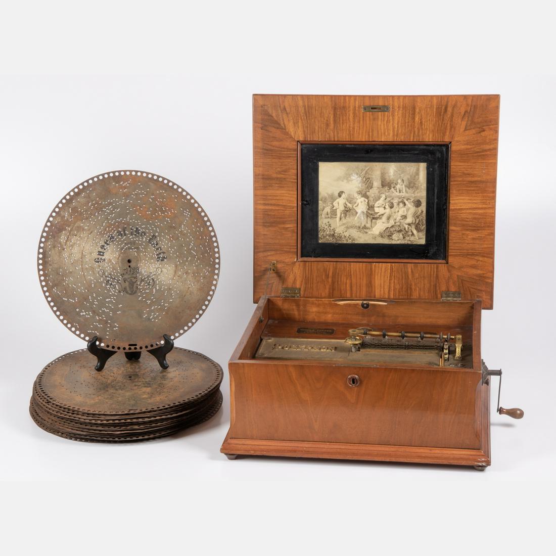 A Polyphon Disk Music Box in a Walnut Veneer Case, 19th: A Polyphon Disk Music Box in a Walnut Veneer Case, 19th Century,Having original Nicole Freres label. Including thirty-five 15 1/2 in. diameter disks.H: 8 3/4 W: 21 D: 18 in.