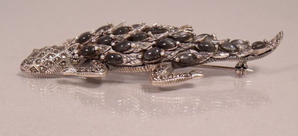 A Sterling Silver, Marcasite and Black Catseye Liz: A Sterling Silver, Marcasite and Black Catseye Lizard Form Brooch, Marked 925. Height: Width: Depth: