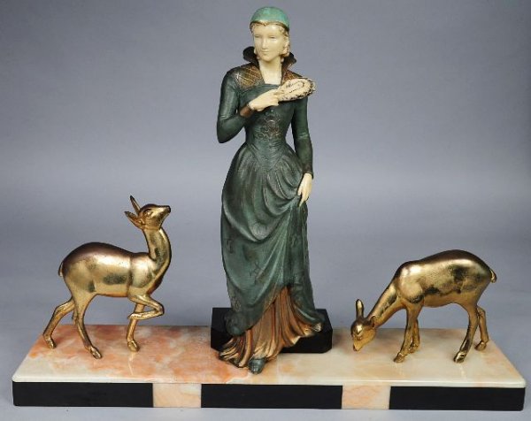 An Art Deco Style Patinated Metal and Celluloid Fi: An Art Deco Style Patinated Metal and Celluloid Figural Group depicting a Female Figure Flanked by Two Deer. H: 16.50 W: 21.50 D: 5.50
