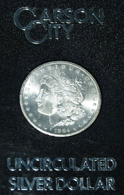 One 1884 CC Morgan One Dollar Coin: In original mint box. Coin is in choice UNC condition