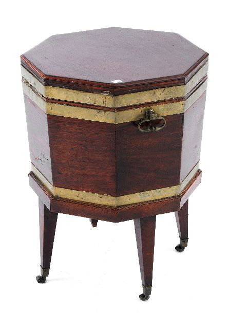 A George III Octagonal Mahogany Cellarette: A George III Octagonal Mahogany and Brass Bound Cellarette, 19th Century, with a hinged cover revealing a zinc interior above square tapering legs ending on brass casters. Note Condition: Surface wear