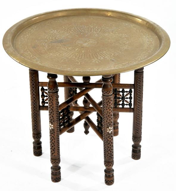A Persian Carved Hardwood Folding Brass Tray Table w: A Persian Carved Hardwood Folding Brass Tray Table with Mother of Pearl Inlay, 20th Century. HEIGHT: 20.5 WIDTH: 25