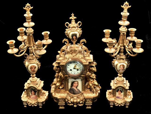 A French Patinated Metal and Porcelain Garniture Cl: A French Patinated Metal and Porcelain Garniture Clock Set, 20th Century. HEIGHT: 22 WIDTH: 12 DEPTH: 6