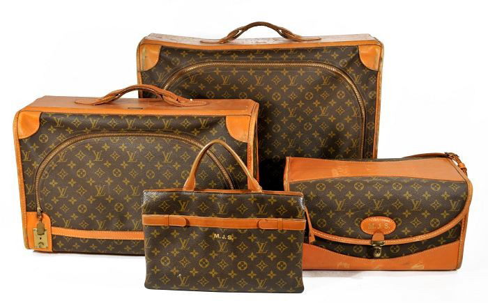A Set of Vintage Louis Vuitton Luggage,: A Set of Vintage Louis Vuitton Luggage, comprising two suitcases, a purse and a cosmetic case, retailed by Saks 5th Avenue. Note condition: surface wear to leather. Largest, h. 18.5 x w. 23 x d 8 ins.