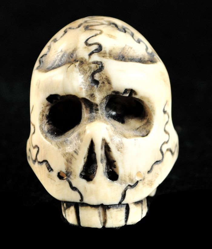 A Carved Ivory Netsuke,: A Carved Ivory Netsuke, Depicting a skull, signed by artist on base. h: 1.25 in.