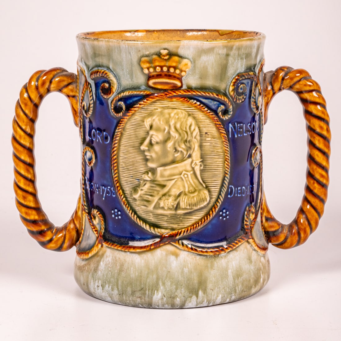 A Royal Doulton Two-Handled Cup: A Royal Doulton Two-Handled Cup, Commemorating Lord Nelson, On the 100th Anniversary of the Battle of Trafalgar. With Royal Doulton stamp to underside. H: 5 7/8 W: 4 3/8 D: 7 in.