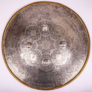 Indo Persian Iron and Brass Shield: An Indo Persian Iron and Brass Shield, 19th Century, Having incised and pierced floral and vine decoration with four floral form metal ornamental bosses. D: 19 in. From the Estate of John A.