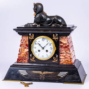 An Egyptian Revival Mantle Clock: An Egyptian Revival Mantle Clock, 19th Century. With key and pendulum. H: 15 W: 11 1/4 D: 7 1/2 in. From the Estate of John A. Davidson, Jr. Proceeds to benefit the APL of Lorain County and the Dittri