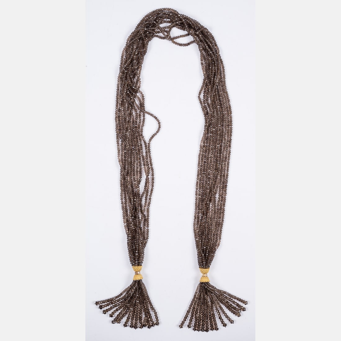14kt Gold And Smoky Quartz Necklace: A 14kt Gold And Beaded Smoky Quartz Lariat-Style Necklace, Twelve strands of faceted smoky quartz beads are strung on silk cord, with 14k gold beaded tassel features at either end. Can be worn various
