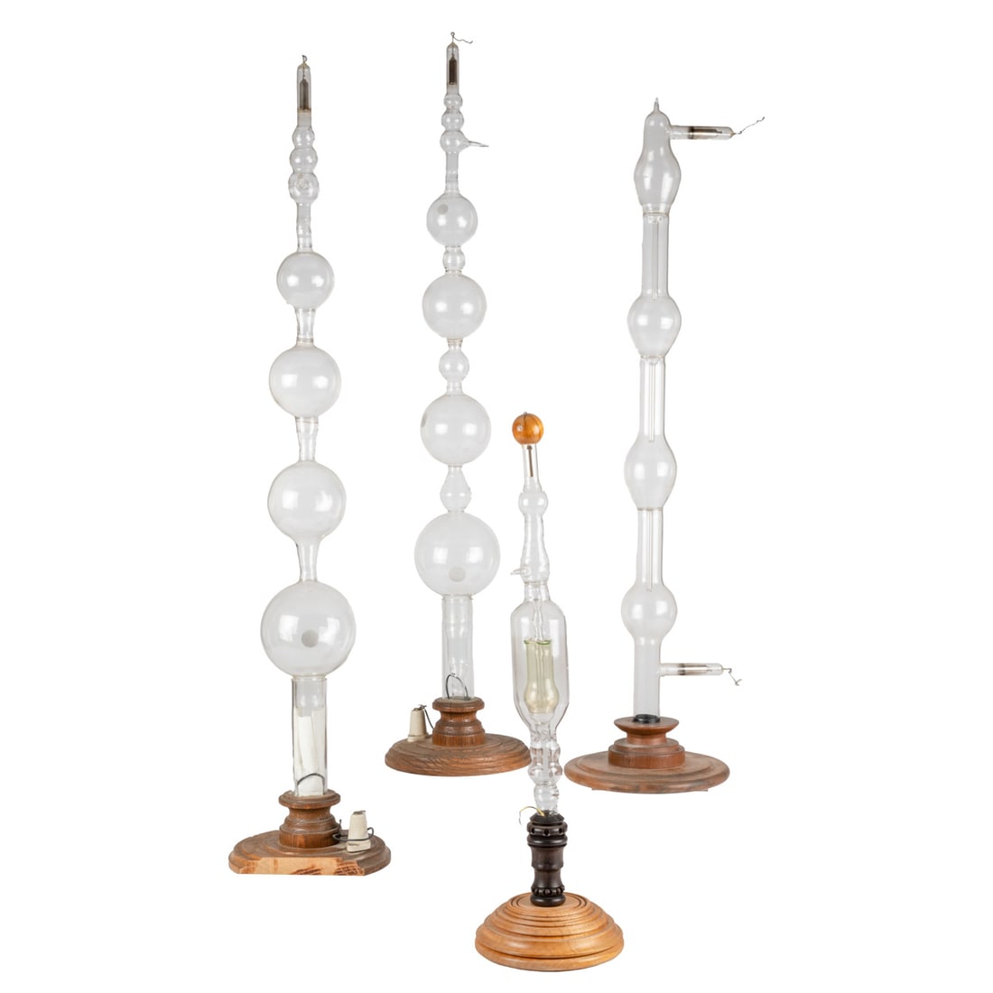 Four Geissler Vacuum Luminous Glass Tubes: Four Geissler Vacuum Luminous Glass Tubes, Early 20th Century. Mounted on Turned Wood Stands. H: 34 W: 7 D: 7 in. From the Estate of John A. Davidson, Jr. Proceeds to benefit the APL of Lorain County 