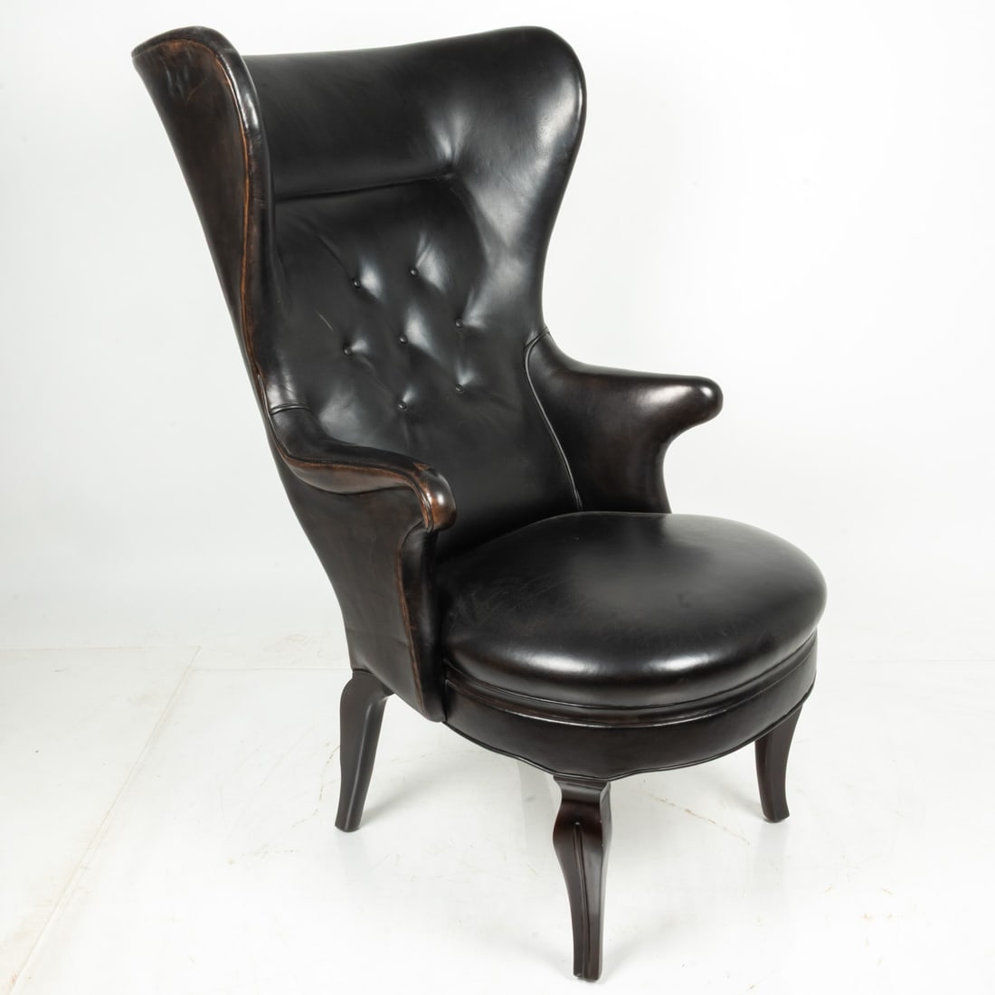 A Frits Henningsen Style Leather Wingback Chair,: A Frits Henningsen Style Leather Wingback Chair 20th Century. Having stained mahogany legs, H: 48 1/2 W: 27 D: 36 in. Property from the Toby Devan Lewis Collection.