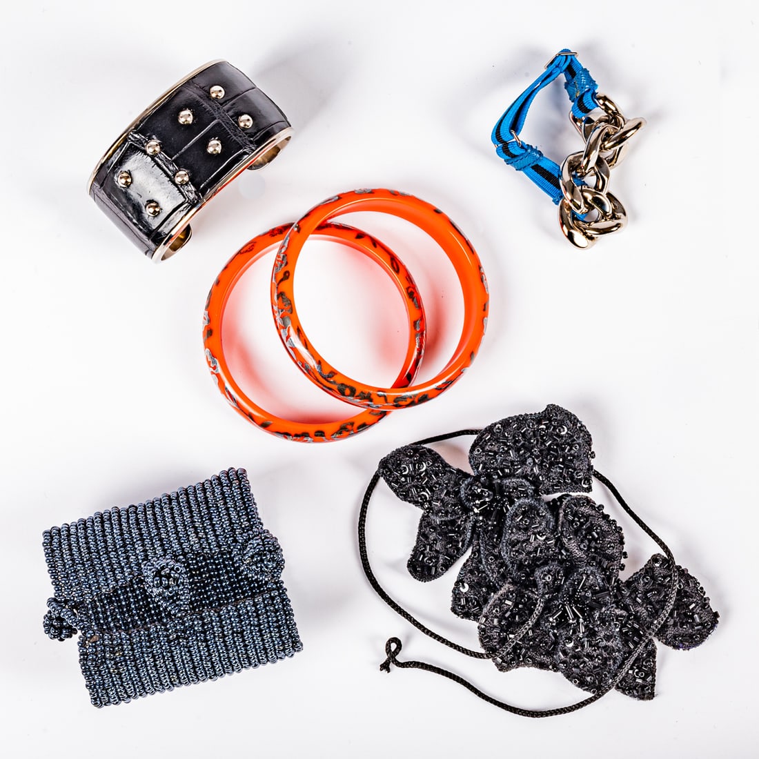 Group Of Costume Jewelry: Group Of Costume Jewelry A silver colored metal and leather bracelet by TODS. Marked: TODS. A pair of beaded black floral fabric brooches. A pair of red acrylic and silvered bangle bracelets. A silver