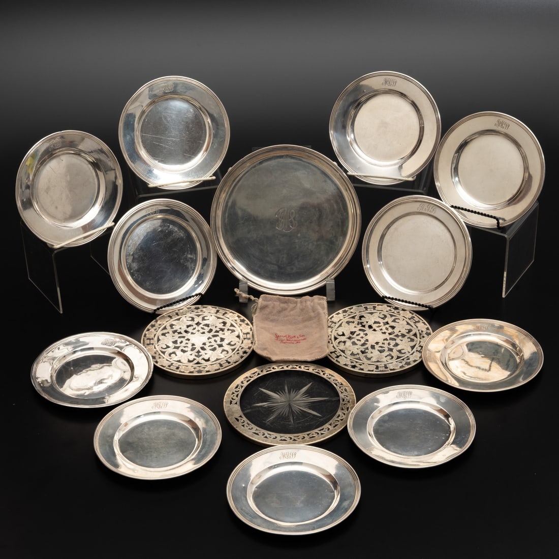 11 Sterling Silver Trivets and Plates: Eleven International Monogrammed Sterling Plates, Trivets, and a Salver, 20th Century, Includes: In the Lord Saybrook Pattern, an S. Kirk monogrammed sterling silver salver; a pair of glass trivets wi
