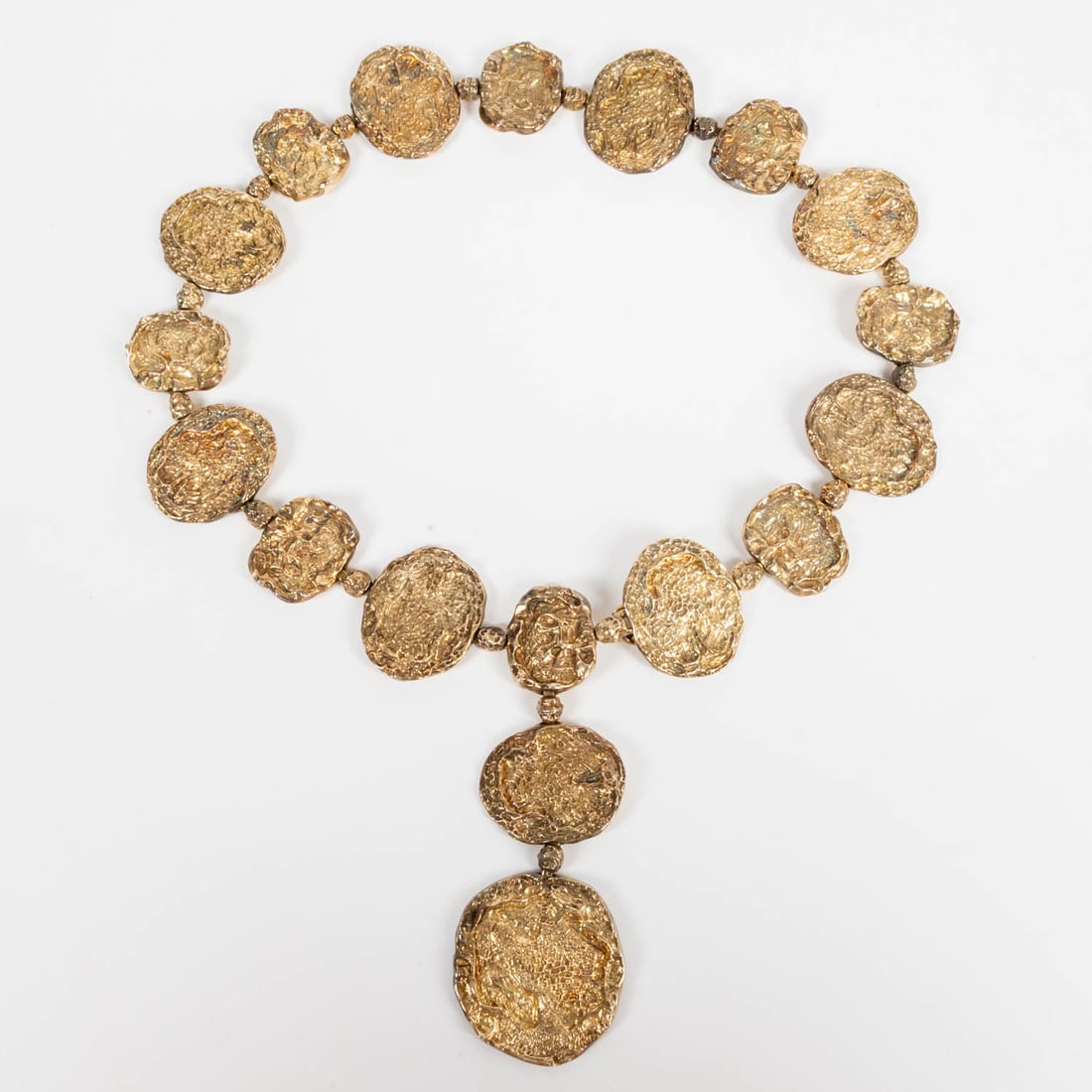 Cartier Gold Vermeil 'Jackie O' Belt: A Cartier Gold Vermeil over Sterling Silver 'Jackie O' Belt, 1970s. Marked Cartier Sterling. Length: 25in. with a 5in. drop. 18 textured discs 1 - 2in. each. This iconic Cartier belt was made